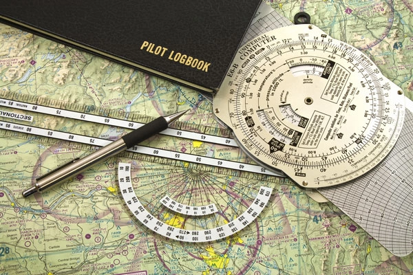 Pilot logbook and chart on a table at Solid Ground Aviation