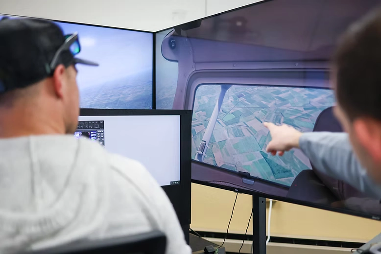 Instructor pointing at the simulator panel during a lesson